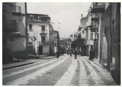 Foto della via Vittorio Emanuele negli anni '50 in cui è possibile apprezzare l'antica pavimentazione della strada e del marciapiede.