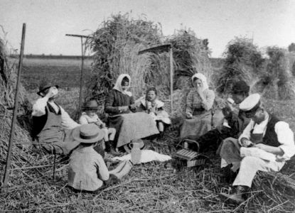Gruppo di contadini mentre riposano durante le attività di lavoro agrario. 